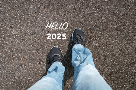 Hello 2025 with woman wearing sports shoes with jeans, top view. New year concept.