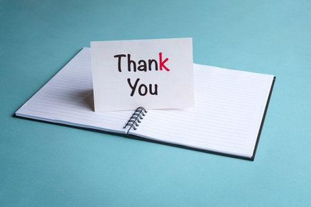 Thank you, a message on a white card on top of a notepad. New job or employment concept.の写真素材