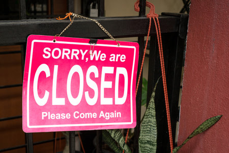 Sorry, We are Closed signboard, tied to a gate of a shop.の写真素材