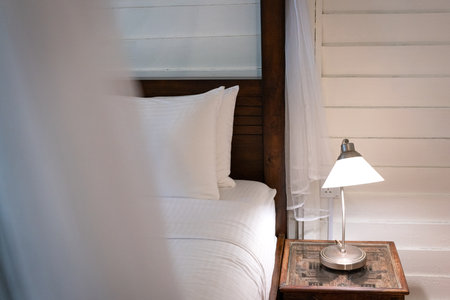 Bedside with side table and lamp on top of it. Cosy living.の写真素材