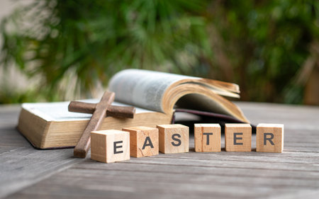 Easter, word on wooden blocks. Bible and crucifix cross at the background.