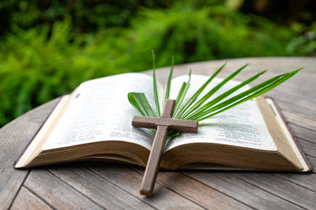 Crucifix cross and palm leaf on top of Holy Bible. Palm Sunday and easter celebration.の写真素材