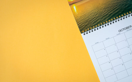 Calendar page on yellow table background. Top view. Copy space.の写真素材