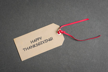 Happy Thanksgiving note on a tag with red ribbon. Top view.の写真素材