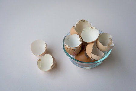Broken chicken egg shells in a bowl isolated on white background.