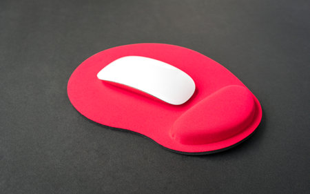 Red color wrist rest mousepad with computer mouse on top.