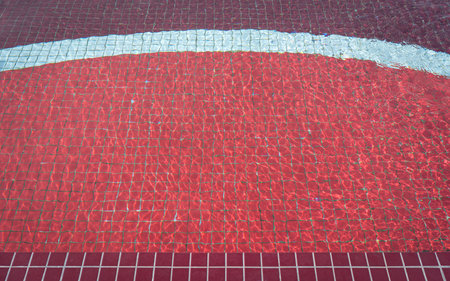 Pool water under the sunlight with red mosaic, swimming pool surface.