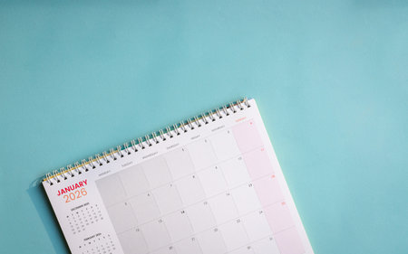 2026 table calendar with January 2026 page on top of light blue plain paper. Top view, copy space.の写真素材