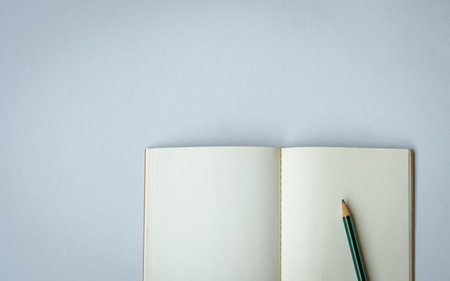 Open notepad with one pencil. Top view. Space for text.の写真素材