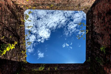 Blue sky in hole in old wall, brick frame.selective focus.