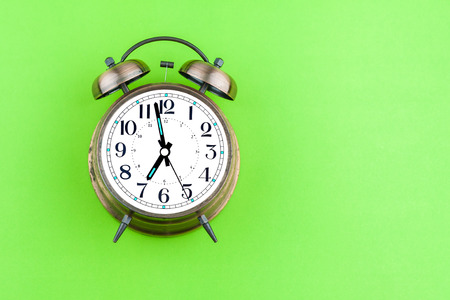 vintage alarm clock on green background