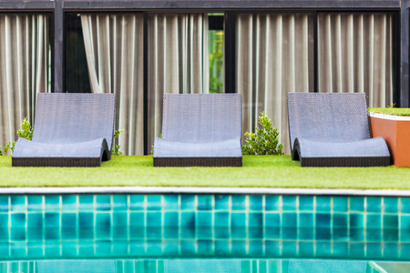 Empty deck chairs with swimming poolの写真素材