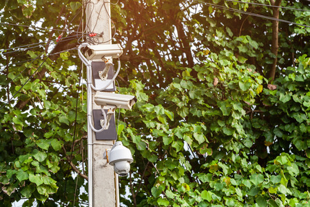 Security surveillance camera on green nature background