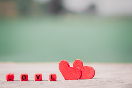 romantic red hearts on a wood table and words with wood cubes.selective focusの写真素材