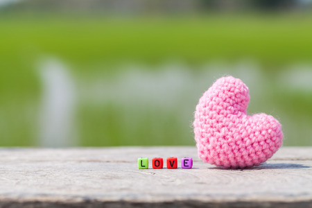 Wooden text block with pink heart  for love and valentine day concept.