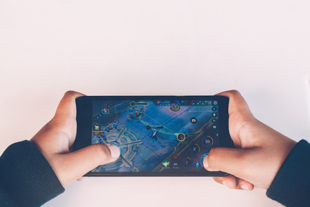 Rayong, Thailand-January 14,2018:Closeup of kid hands playing video games on cell phoneの写真素材