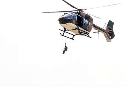 Rayong, Thailand - July 21 2018: the men lowered by a rope under a helicopter on the white background.のeditorial素材