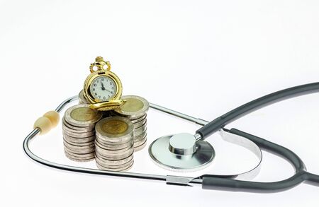 Concept of expensive healthcare with coins and stethoscope on white backgroundの写真素材