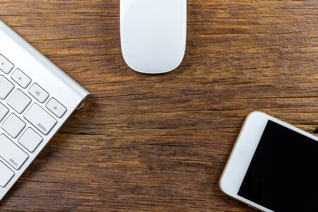 electronic device phone mouse  keyboard technology on wood background