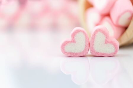 Pink marshmallow in heart shape  on  table with copy space.  Pastel color dessert for background or...