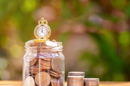 glass jar with retro clock for time to money saving for retirement concept