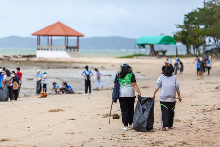 Rayong, Thailand 10 December 2020: Group of volunteers cleaning up beach line at Had Nam Rin.