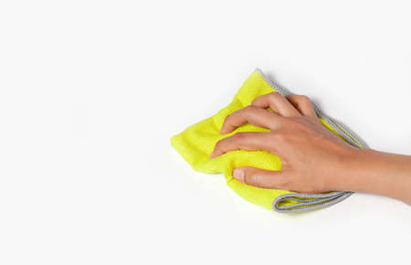 Hand wiping surface with green rag isolated on white
