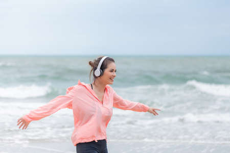 Happy sport woman running on the beach with beautiful smile.の写真素材