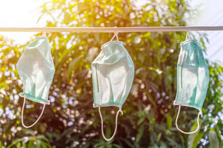 concept.Disposable medical masks hang on a clothesline. Concept. Reuse. Deficitの写真素材