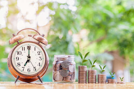 Money coin stack growing graph with alarm clock to profit concept investment business and finance