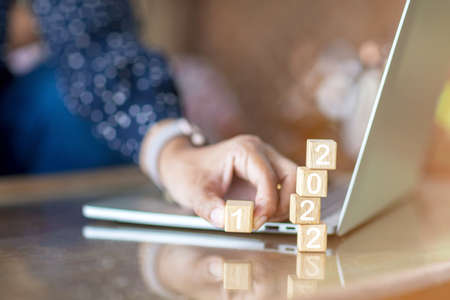 2022 trend concept. hand flipping wooden cubes block for change year 2021 to 2022 New year and holiday concept.selective focus.の写真素材