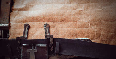 A top view of  vintage typewriter maschine with a brown blank sheet of paper.の写真素材