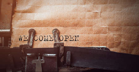 vintage typewriter with a brown sheet of paper and "Welcome open" written on it.の写真素材