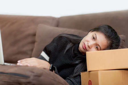 asian woman using laptop online at home. Lady look worried and stressed  arounded with records...