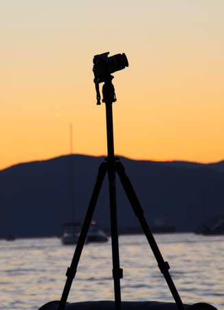 Silhouette of a camera on a tripod at sunsetの写真素材