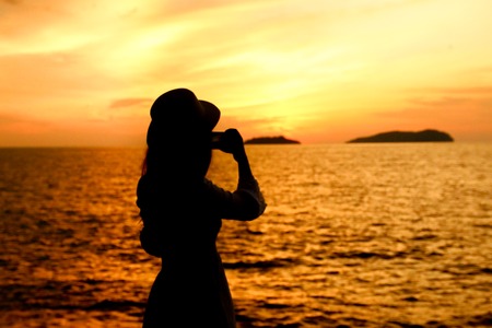Silhouette of a woman under beautiful sunsetの写真素材