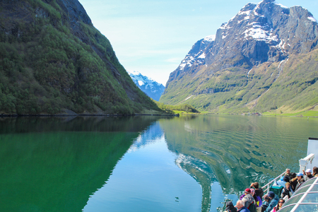 Flam, Norway - May 5 2014: Tourists are enjoying magnificent view of Fjord on board of ferry boat in Norway.の写真素材