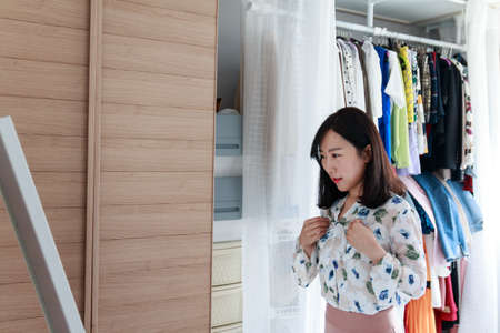 beautiful Asian lady getting ready to go out in front of the mirrorの写真素材