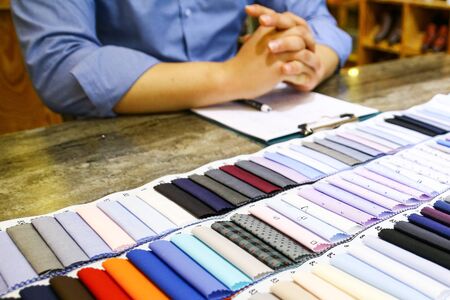 tailor choosing a fabric for his customer in tailor shopの写真素材