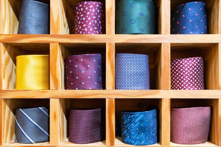 Colorful neckties arranged in a grid shelfの写真素材