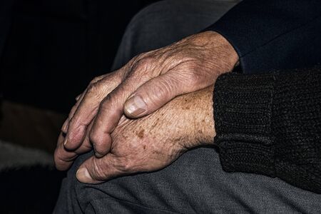 Senior husband touching the hand of his old wife.