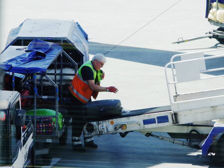 Loading luggage on an airplane at Warsaw airportのeditorial素材