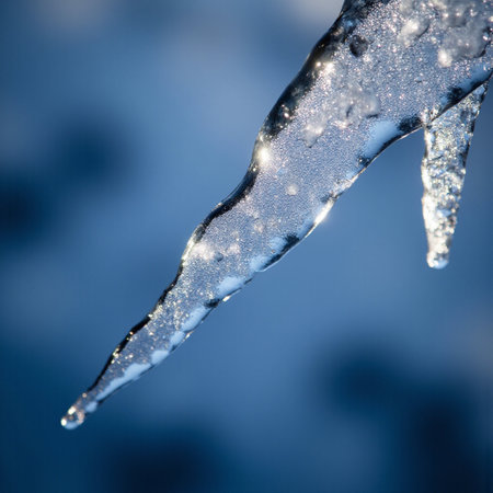 icicle on a blue background with water drops and snowflakesの素材