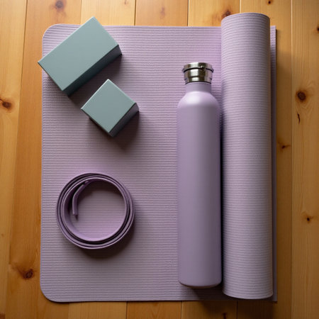 Purple yoga mat, bottle and roller on wooden background. Top viewの素材