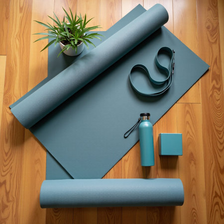 Top view of blue yoga mat and sport equipment on wooden floor.の素材