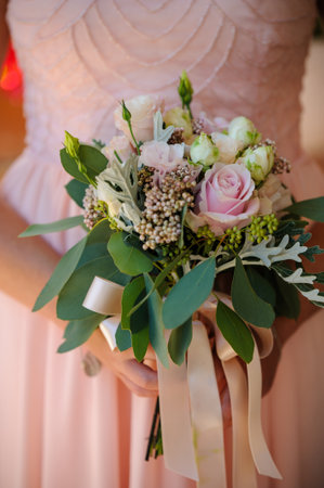Bridesmaids bouquet of pink and cream  flowers against a pink dress.の写真素材