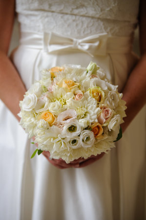 Bridal bouquet yellow and white against a wedding dress.の写真素材