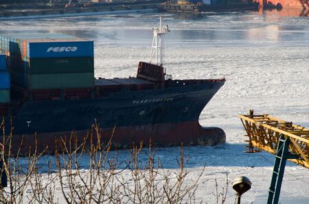 Port of Vladivostok. Container ship in the snowy haze.