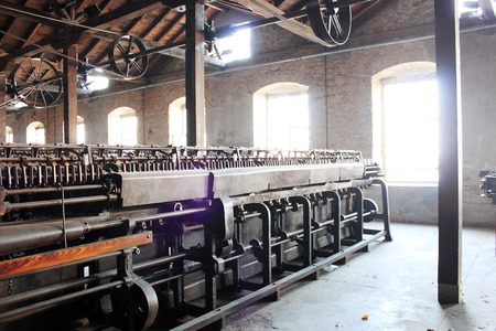 Vintage rusty machines in an abandoned hemp factory front of the light from the windows. Photo taken...