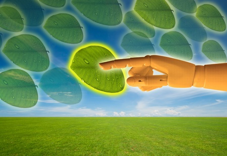 Saved green with touch screen, wooden hand pressing leaf buttonの写真素材